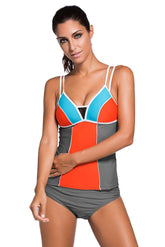 A model wearing a color block tankini swimsuit with lace detailing and grey briefs.