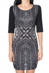 A woman wearing a black and white geometric patterned bodycon dress with half sleeves.