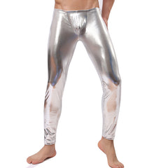 A man wearing silver-colored latex pants that reach from the waist to the ankle, featuring a shiny, smooth texture.