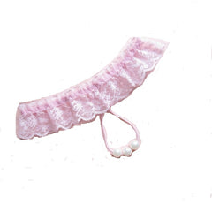A pink crotchless G-string with lace detailing and a small bow at the front, featuring two pearl embellishments.
