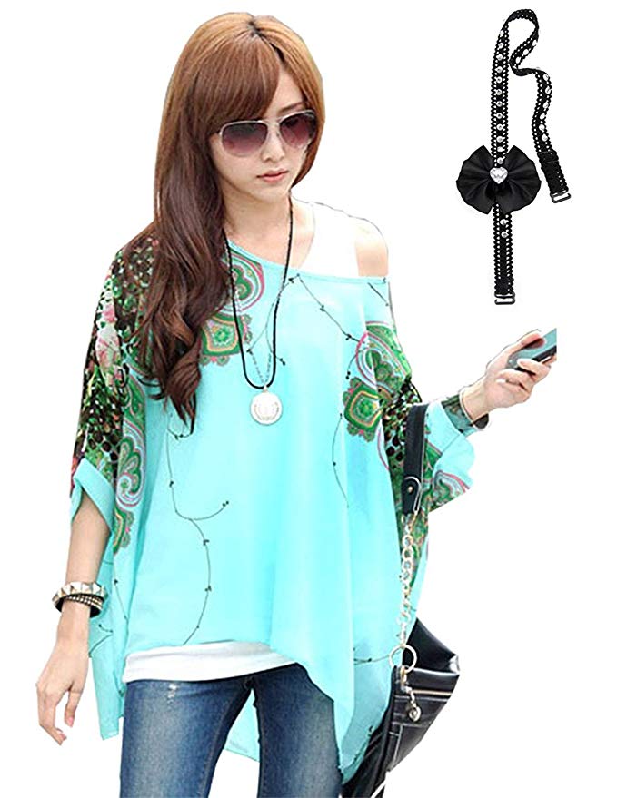 A woman wearing a vibrant green kaftan with geometric patterns, paired with sunglasses and holding a mobile phone.