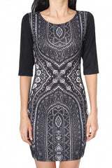 A woman wearing a black and white geometric patterned bodycon dress with half sleeves.